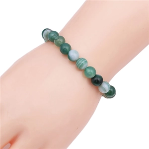 Detailed view of green striped agate beaded stretch bracelet on a display model