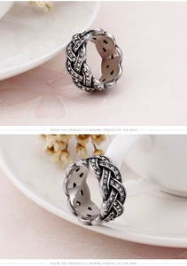 Macro shot of silver metal ring with twisted braid design and white zircon setting