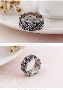 Macro detail of wide vintage titanium steel ring with cross-woven texture and cubic zirconia