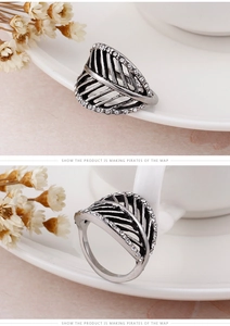 Macro shot of vintage silver feather ring with hollow leaf design and white rhinestones