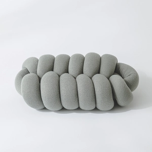 Detail of grey handmade knotted pillow showing soft knitted texture and woven structure