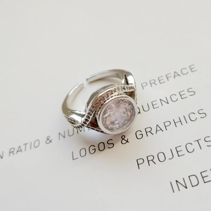 Macro shot of 925 silver ring with sparkling central gem on a book page