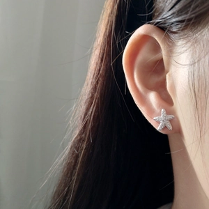 Macro shot of 925 sterling silver starfish stud earrings with pave-set cubic zirconia