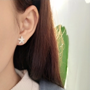 On-ear view of 925 sterling silver starfish stud earrings with micro-inlaid crystals