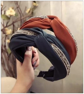 Détail des serre-têtes en tissu bleu marine et orange avec ornements en strass