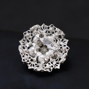 Silver vintage alloy brooch with pearl and crystal, back view of hollow floral design