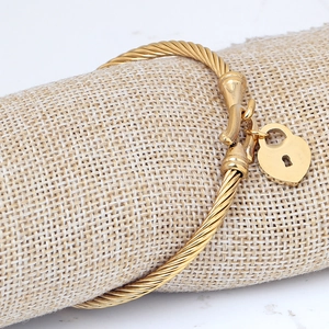 18K gold heart lock cable twisted bangle featuring a minimalist textured finish