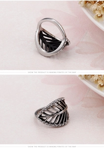 Detail of silver feather ring with black texture, leaf pattern and sparkling crystals