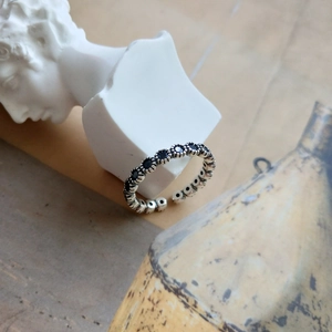 Detail of vintage S925 sterling silver open ring with round black zircon stones and beads