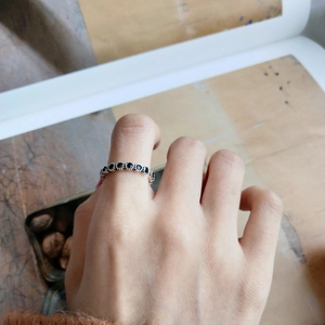 Retro S925 silver ring featuring embedded black zircon stones worn on person's finger