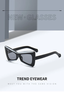 Detail shot of black cat-eye sunglasses featuring white decorative edges and smoke grey lenses
