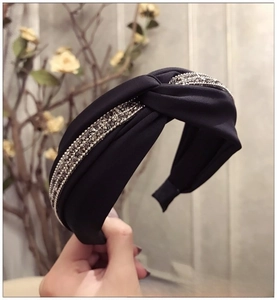 Détail d'un serre-tête large en satin bleu marine avec perles de cristal et nœud croisé