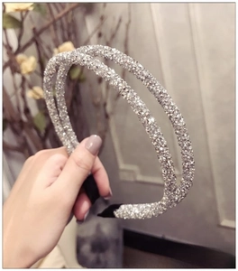 Detailed view of a double-layered silver headband with sparkling rhinestones decoration