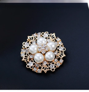 Macro shot of gold alloy flower brooch with white pearls and sparkling crystal center