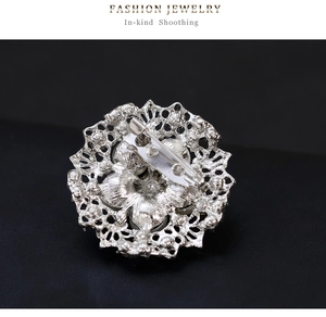 Macro shot of silver alloy brooch back featuring pin clasp and hollow petal texture