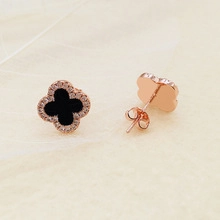 Detailed close-up of clover stud earrings in rose gold with black stone and cubic zirconia