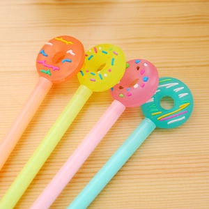 Creative lollipop donut pens in orange yellow pink and teal on wood background