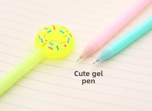Close-up of pastel gel pens with a colorful donut topper on a lined paper background