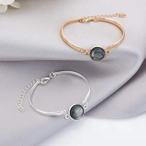Detail of silver and rose gold adjustable bracelets with round abalone shell inlays