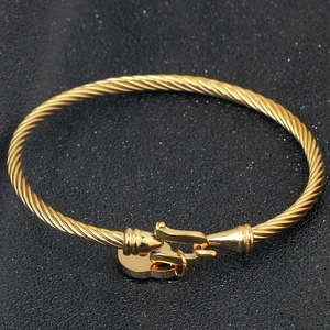 Detailed close-up of 18K gold heart lock bracelet with elegant twisted cable texture