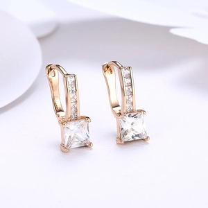 Golden earrings with square-cut clear zircon and side pavé accents on white background