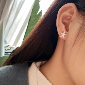 Side view of model wearing a 925 sterling silver starfish stud earring with white zircons