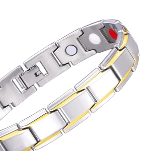 Detail of silver and gold metal bracelet with magnetic therapy stones on white background