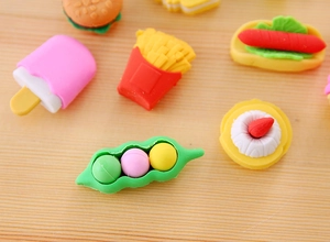 Macro shot of creative food-shaped erasers including fries and ice cream on wood