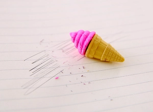 Close-up of pink ice cream cone eraser on notebook paper with clean erasing effect