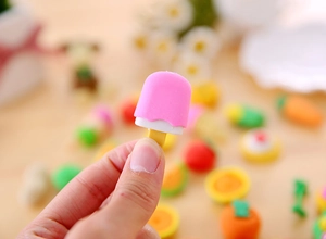 Close-up of pink ice cream shaped eraser held in hand, colorful stationery detail