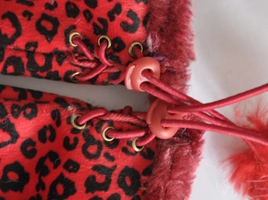 Detail of red leopard print fingerless gloves showing elastic drawstring and toggle closure