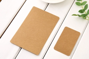 Flat lay of small and large brown kraft paper cards on a white wooden surface