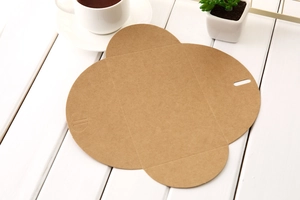 Flat lay of brown kraft paper gift envelope with flower petals fold on wood background