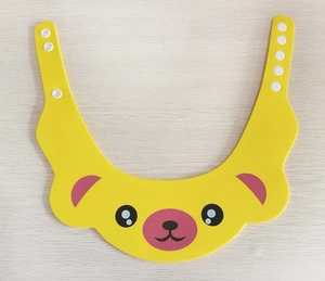 Detail of adjustable snaps on a yellow cartoon bear baby shower cap for ear protection