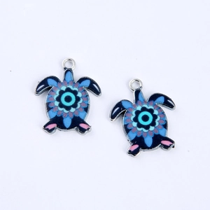 Detail of metal turtle charms with colorful enamel mandala patterns and hanging loops