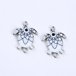 Detail of white enamel sea turtle connectors with silver frames for DIY jewelry