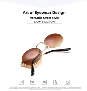 Detail view of oval retro sunglasses with gold metal frame and brown gradient lenses