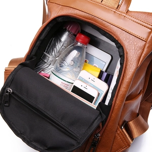 Brown faux leather backpack with large capacity interior showing tablet and accessories