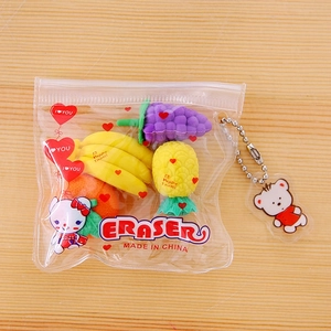 Detail view of cute fruit-shaped erasers set with a bear pendant in a transparent pouch