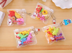 Flat lay of colorful cartoon food and dinosaur eraser sets in bags with bead chains