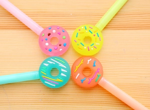 Close-up of creative donut-topped gel pens in various colors on a wooden surface