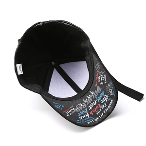 Détail de la casquette noire avec design graffiti coloré et étiquette intérieure