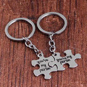 Detail of puzzle piece keychains in silver metal with You Are My Person engraving