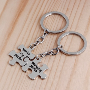 Detailed macro view of puzzle piece keychains with You Are My Person engraving