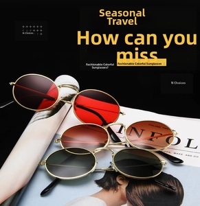 Three oval metal sunglasses in red, tea, and black lenses on a fashion magazine