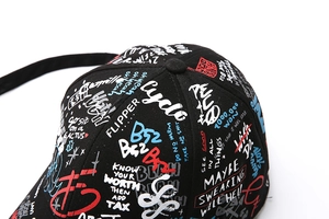 Gros plan sur l'imprimé graffiti coloré et le sergé de coton d'une casquette noire