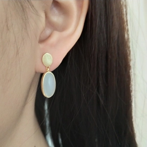 925 silver gold-plated earrings featuring a round disc and oval light blue stone on a model