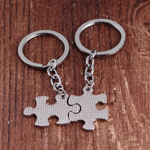 Silver metal puzzle piece keychains with 'You are my person' text on wood background