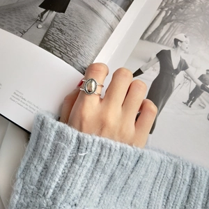 Detailed view of silver oval signet ring with woven texture on vintage book background