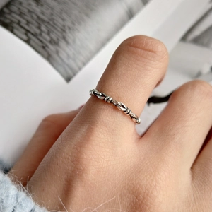 Macro shot of a minimalist 925 sterling silver knotted chain ring with vintage oxidized finish